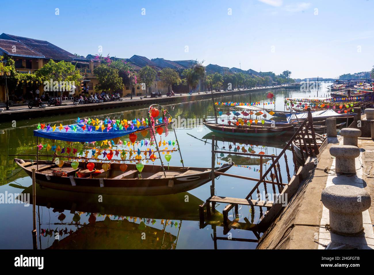 Una fila di piccole barche in legno ancora parcheggiate al mattino presto. Foto Stock