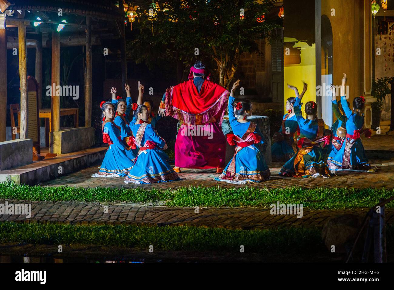 Un gruppo di giocatori cantano e ballano in costumi presso Hoi An Impressions. Foto Stock