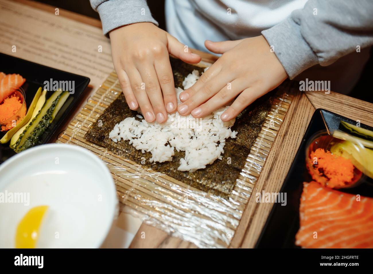 I bambini che fanno il sushi alla lezione principale. Bambini, istruzione e intrattenimento concetto Foto Stock