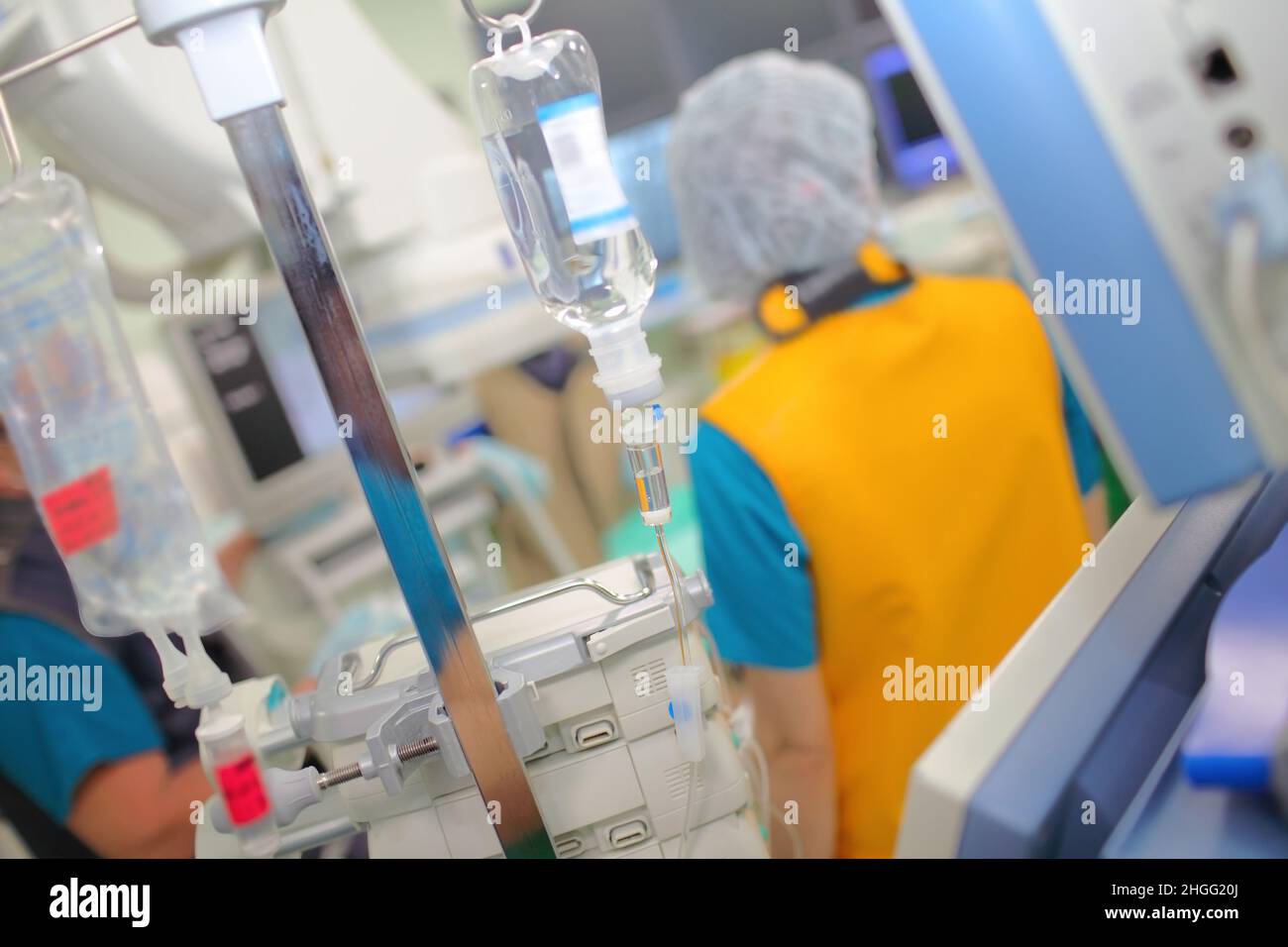 Personale medico nella sala operatoria a raggi X sullo sfondo dell'infusione endovenosa e dell'apparecchiatura. Foto Stock