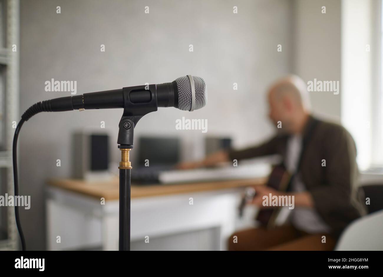 Primo piano del microfono sul rack in piedi in studio di musica su sfondo di musicista. Foto Stock