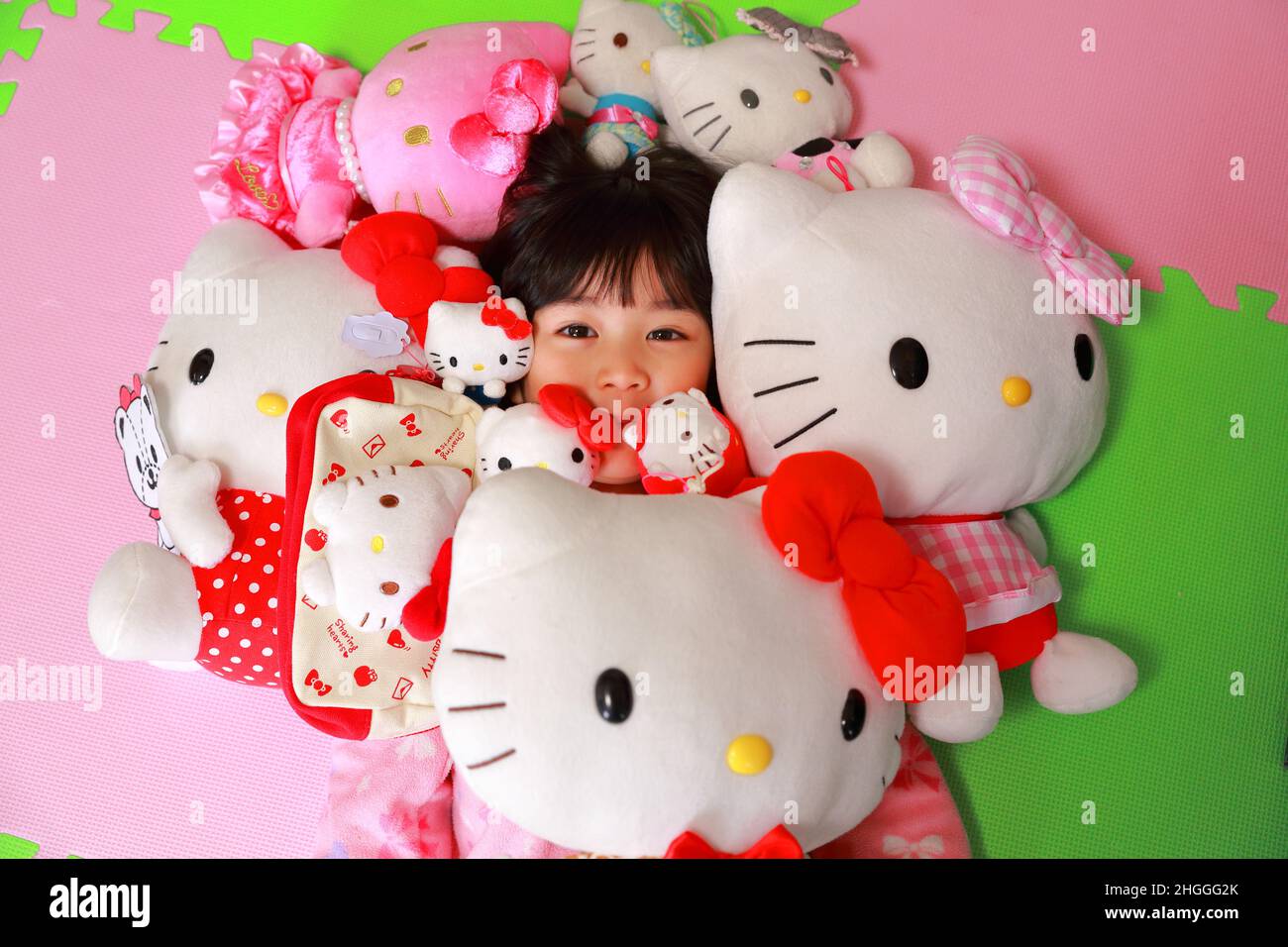 Bambino a casa con il suo carino preferito Ciao Kitty ripieni Toys Foto Stock