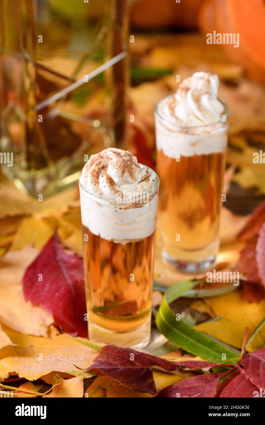 Due vodka con torta di zucca crema alla cannella spara in bicchieri da shot. Queste bevande sono facili da preparare e perfette per l'autunno. Prova queste bevande boozy al tuo Foto Stock