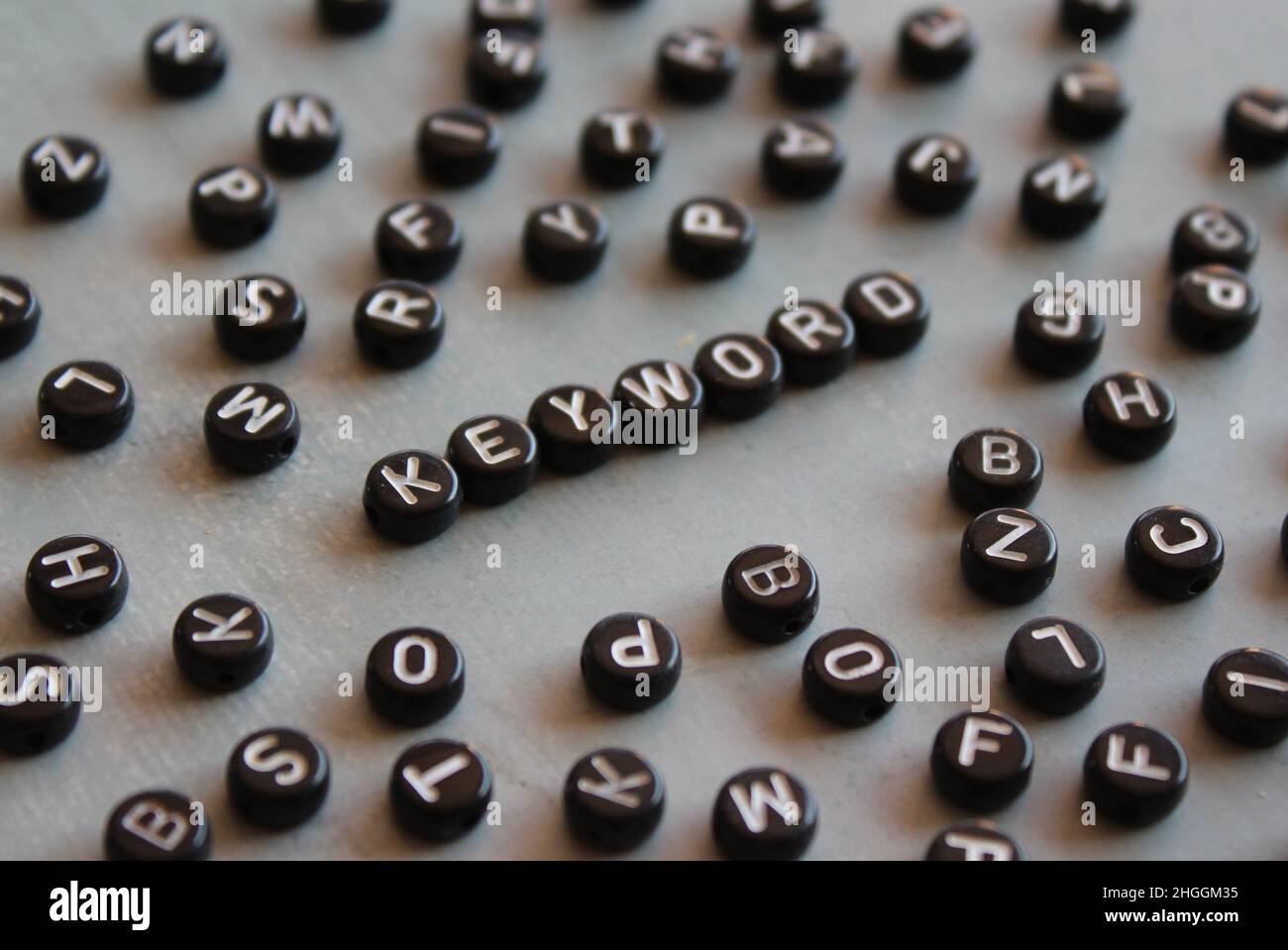 Perline alfabetiche con PAROLA CHIAVE di testo su pavimento in cemento Foto Stock