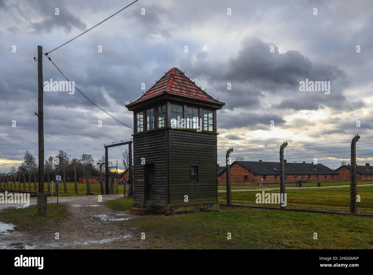 Recinzione di filo spinato, una torre di guardia e caserme presso l'ex campo di concentramento e sterminio nazista di Auschwitz II-Birkenau a Oswiecim, Polonia, il 3 gennaio 2022. Foto Stock