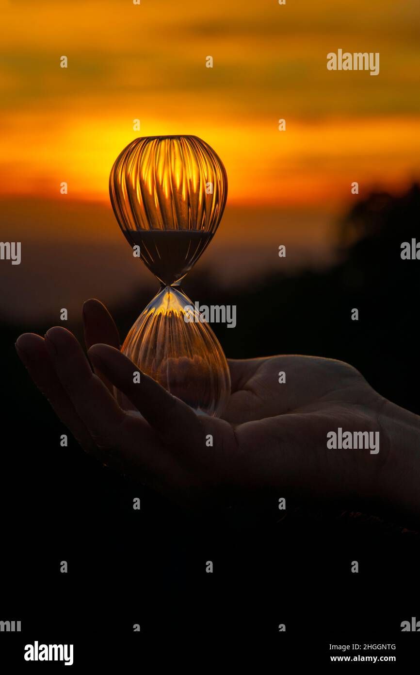 il pianeta è in pericolo .. il tempo sta per esaurire .. quanti altri tramonti ci sono? clessidra sullo sfondo del tramonto Foto Stock