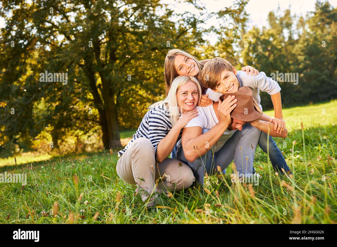 Famiglia felice e due bambini che abbraccia un prato in natura Foto Stock