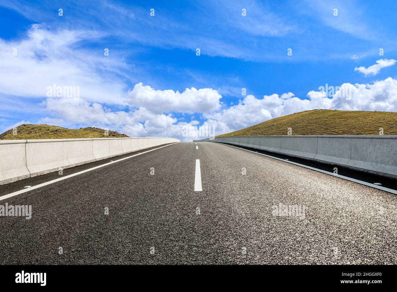 Strada diritta e paesaggio naturale di montagna sotto cielo blu.Paesaggio e autostrada.sfondo strada all'aperto. Foto Stock