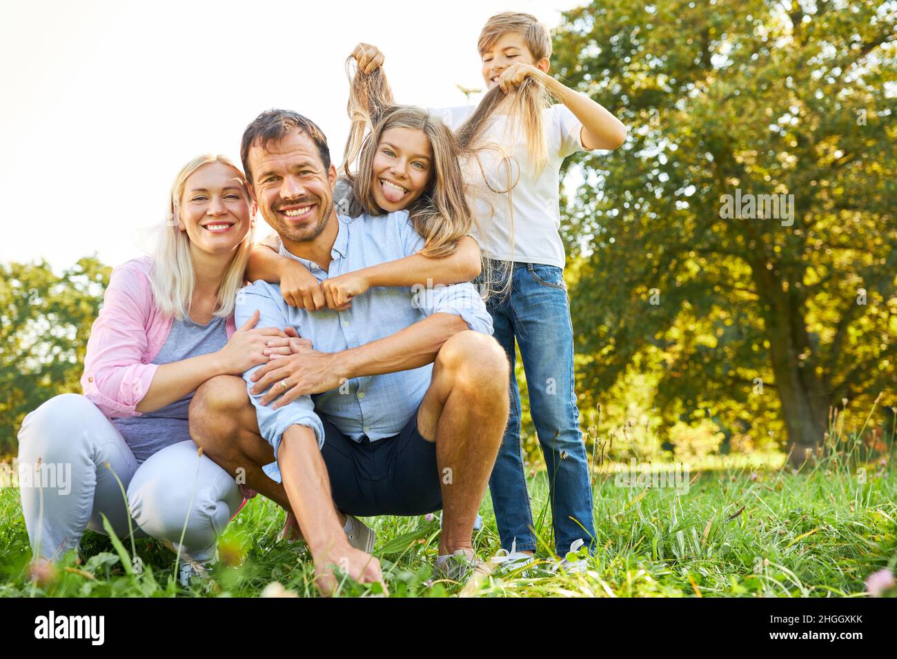 Famiglia felice e due bambini in natura in estate facendo male e ingannare intorno Foto Stock