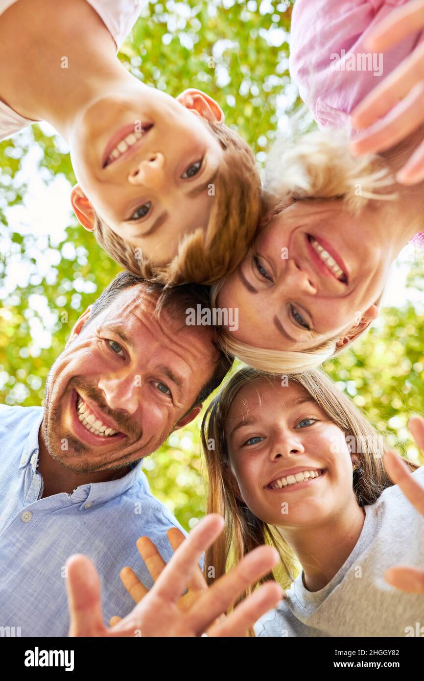 Piccola famiglia felice con genitori allegri e due bambini in natura Foto Stock