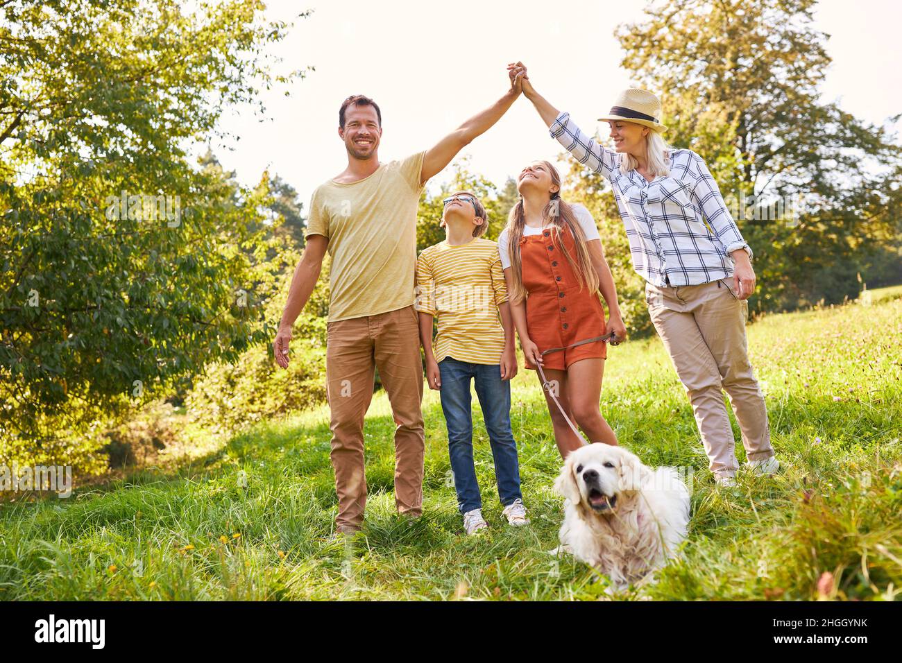 La famiglia con due bambini e un cane si divertono in un'escursione estiva nel parco Foto Stock
