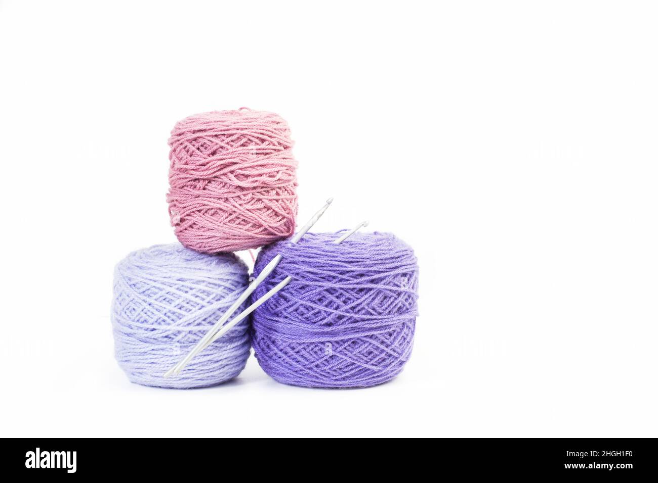 Palline di lana rosa e viola su sfondo bianco con spazio per la copia Foto Stock