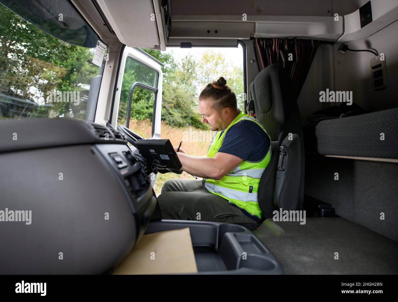 Un driver HGV1 completa alcuni documenti in un laico, Regno Unito. Foto Stock