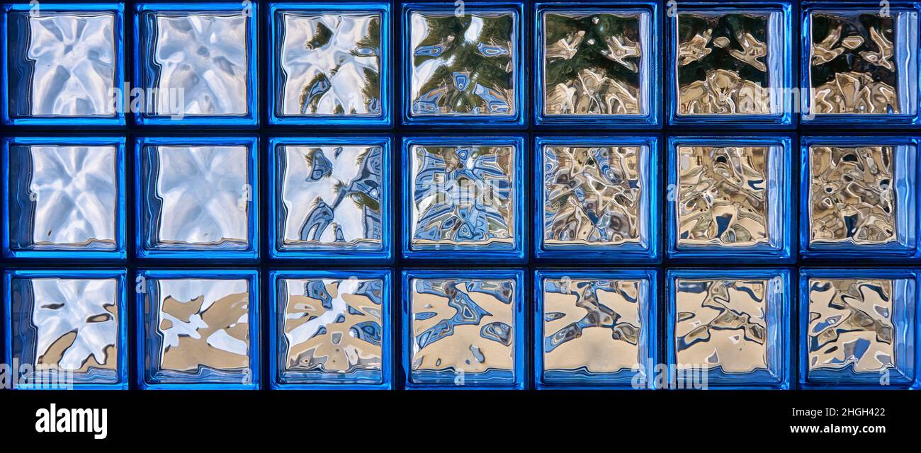 Motivo di parete a blocchi di vetro blu come sfondo panoramico per opere astratte. Foto Stock