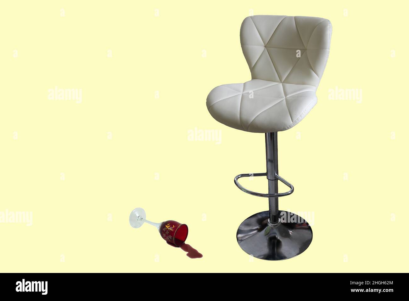 Sgabello da bar e bicchieri da vino su sfondo chiaro. C'è un bicchiere di vino versato accanto alla sedia. Foto Stock