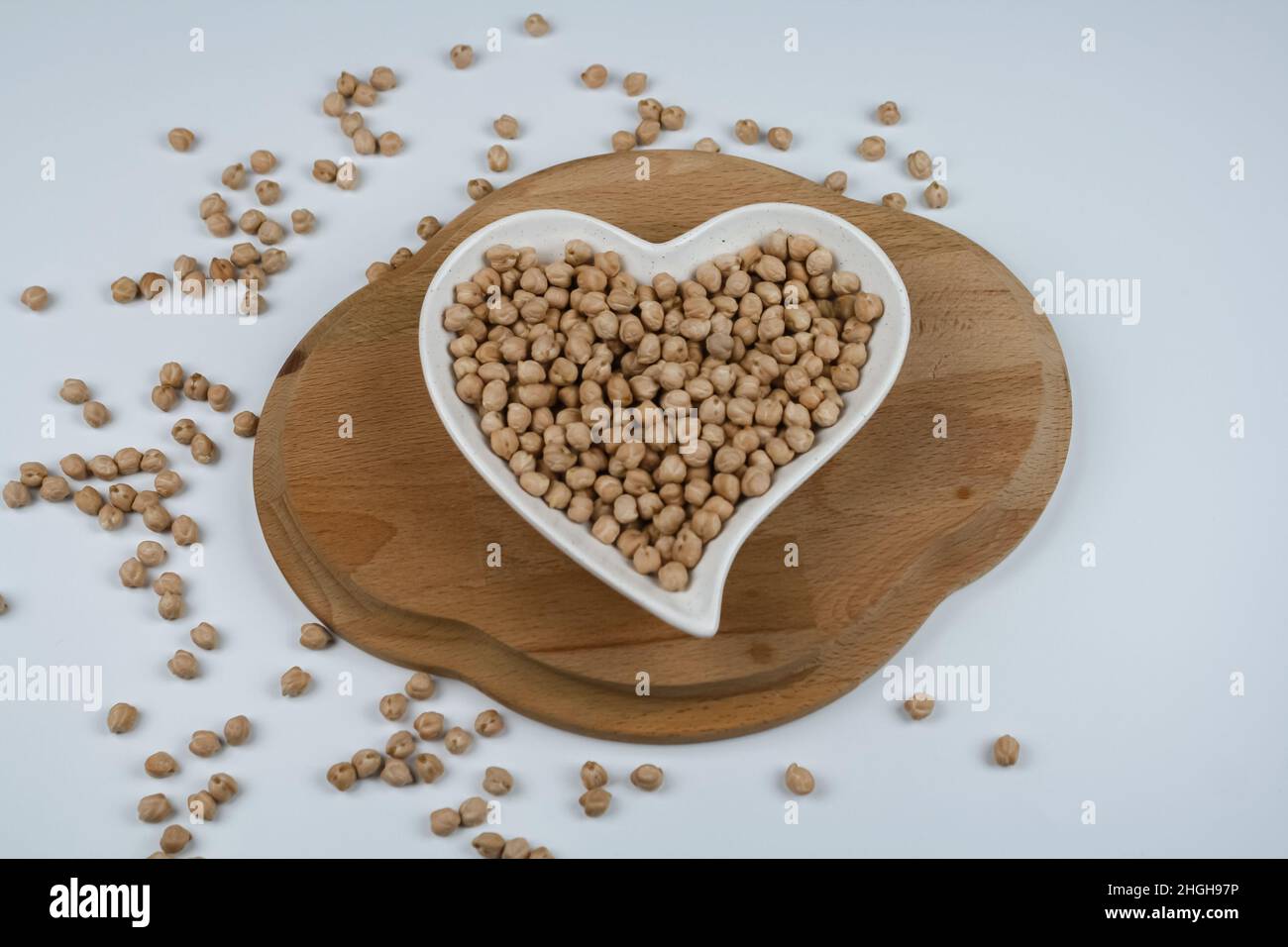 Ceci crudi sul piatto a forma di cuore e asciugamano. Vista dall'alto. Foto Stock