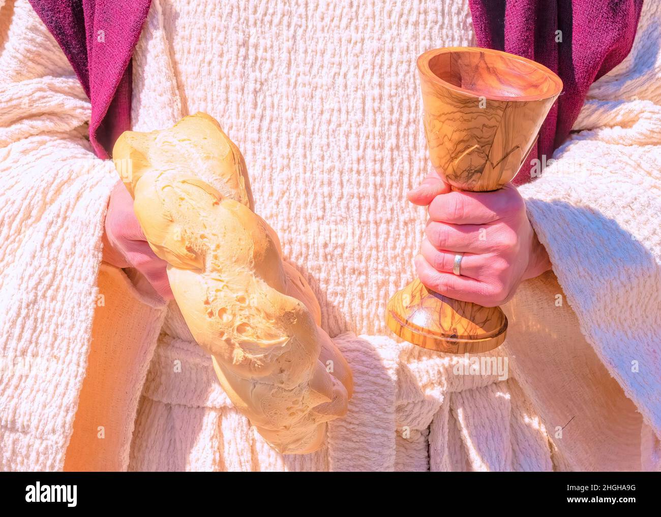 Simboli religiosi di pane e vino nelle mani di un sacerdote. Ottimizzazione digitale Foto Stock