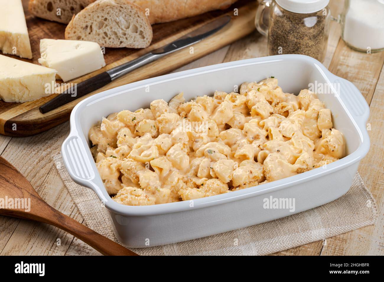 Macaroni e formaggio in casseruola bianca su tavola di legno Foto Stock