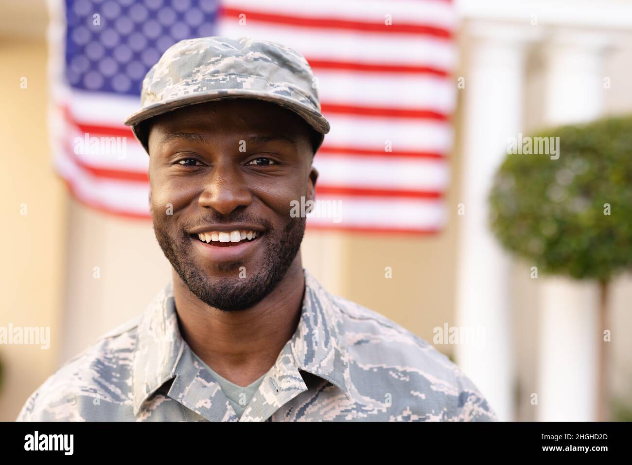 Ritratto di sorridente soldato afroamericano maschio indossando camouflage uniforme e cappello Foto Stock