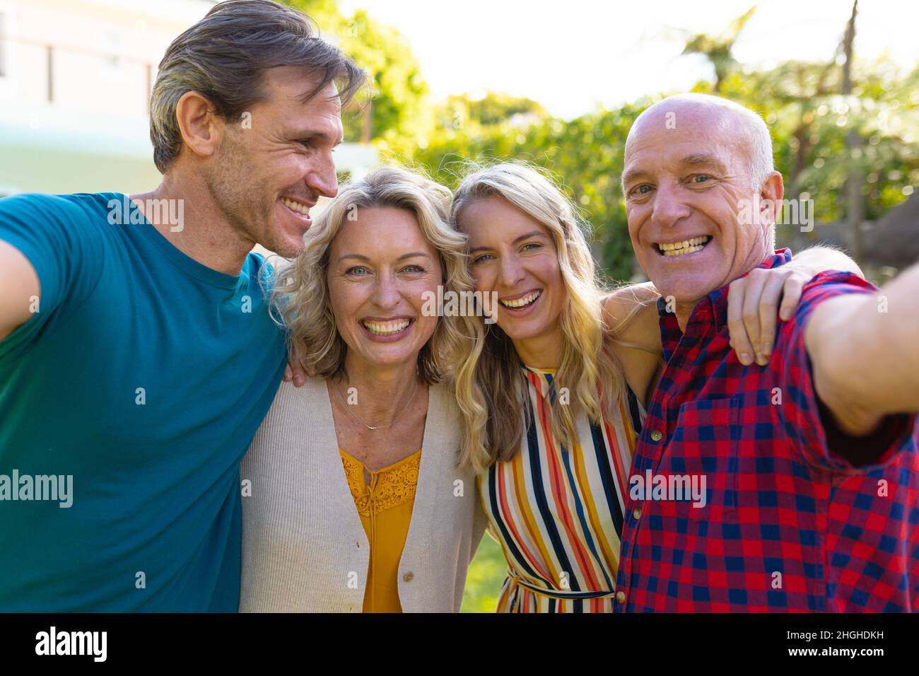Ritratto di famiglia caucasica di due generazioni che prende insieme selfie nel giardino Foto Stock