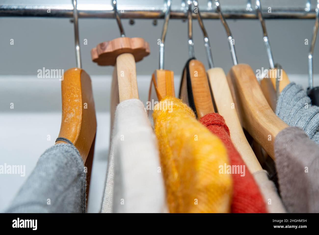 Abiti colorati nel guardaroba con protezione della falce in pino svizzero Foto Stock