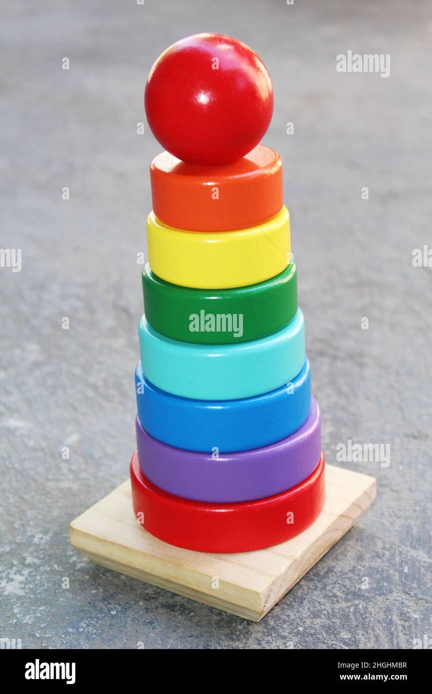 Pile in legno a colori arcobaleno a forma di torre giocattolo educativo per bambini Foto Stock