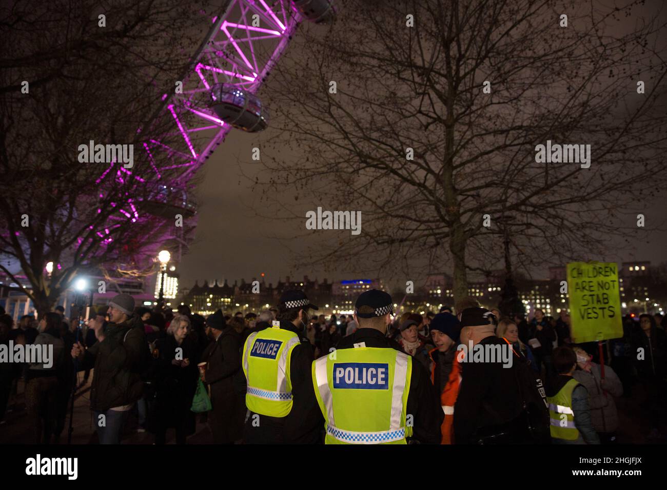 Gli ufficiali di polizia guardano i partecipanti che si riuniscono per un raduno di libertà contro le misure legate a Covid, come i passaporti dei vaccini vicino a London Eye su Southbank Foto Stock