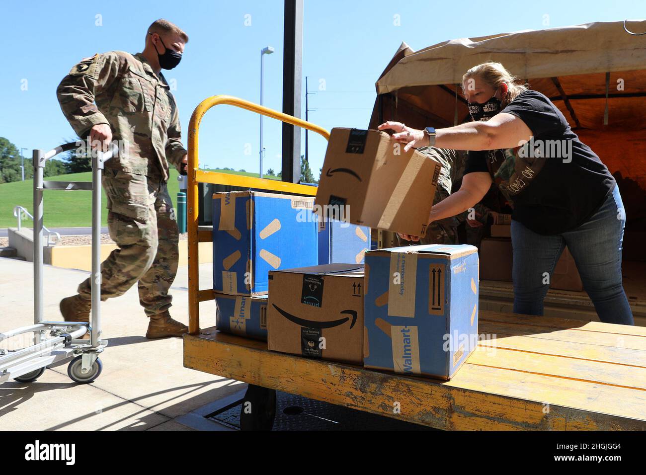 I soldati della Guardia Nazionale del Nord Carolina e il personale dei programmi familiari scaricano le forniture scolastiche donate dalla John Deere Turf and Utility Division come parte dei programmi per famiglie NCNG della 2021 zaino Brigade Drive della NCNG presso la sede centrale della forza mista NCNG a Raleigh, North Carolina, 19 agosto 2021. I membri del gruppo di apprezzamento militare dell'azienda, North Carolina Military Employee Resource Group, si sono Uniti ai soldati NCNG all'inizio del giorno per caricare le forniture in un veicolo tattico medio leggero per il trasporto dagli uffici dell'azienda a Cary alla sede centrale di NCNG per la successiva distribuzione a Guard fami Foto Stock