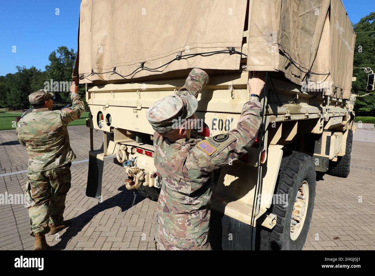 I soldati della Guardia Nazionale del North Carolina si preparano ad aiutare i dipendenti della John Deere Turf and Utility Division a caricare le forniture scolastiche donate come parte dei 2021 zaino Brigade Drive della Società per i programmi familiari della Guardia Nazionale del Nord Carolina a Cary, North Carolina, 19 agosto 2021. I membri del gruppo di apprezzamento militare dell'azienda, North Carolina Military Employee Resource Group, si sono Uniti ai soldati NCNG per caricare le forniture in un veicolo tattico medio leggero per il trasporto dagli uffici dell'azienda a Cary alla sede centrale NCNG a Raleigh, North Carolina, per la successiva distribuzione alle famiglie della Guardia Foto Stock