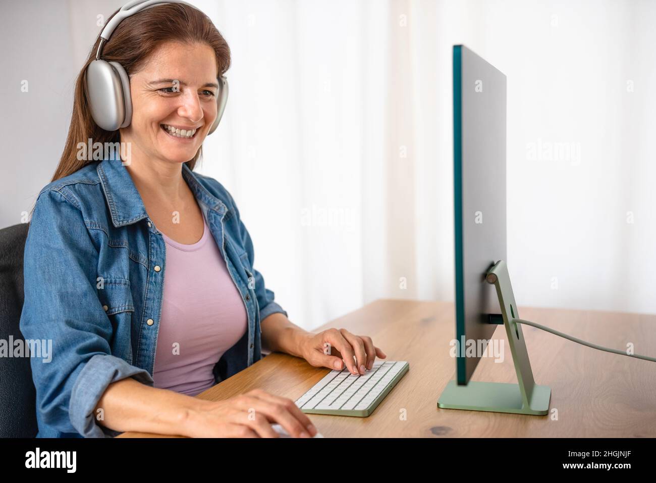 Donna felice che lavora in modo intelligente utilizzando il computer dal suo studio di casa - concetto di tecnologia Foto Stock