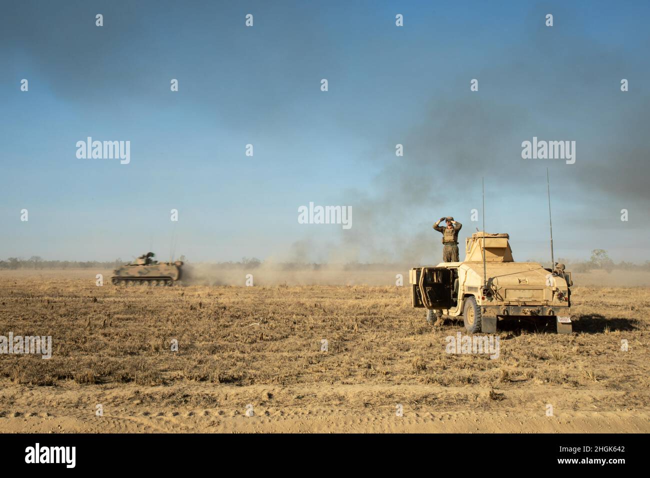 Un vettore Armored del personale dell'esercito australiano M113AS4 passa dai marines degli Stati Uniti con il plotone rosso combinato del team di Anti-Armor, forza rotazionale marina - Darwin, tenendo una linea di fase per lo scenario di fuoco vivo durante l'esercitazione Koolendong, Bradshaw Field Training Area, NT, Australia, 28 agosto 2021. Il plotone CAAT Red era delimitato in un campo con varie armi per cogliere una linea di fase chiave che consentiva ad altri veicoli tattici di passare attraverso e procedere con l'esercizio. Esercizi come Koolendong convalidano la capacità della MRF-D e della forza di difesa australiana di condurre un comando e un controllo rapido Foto Stock
