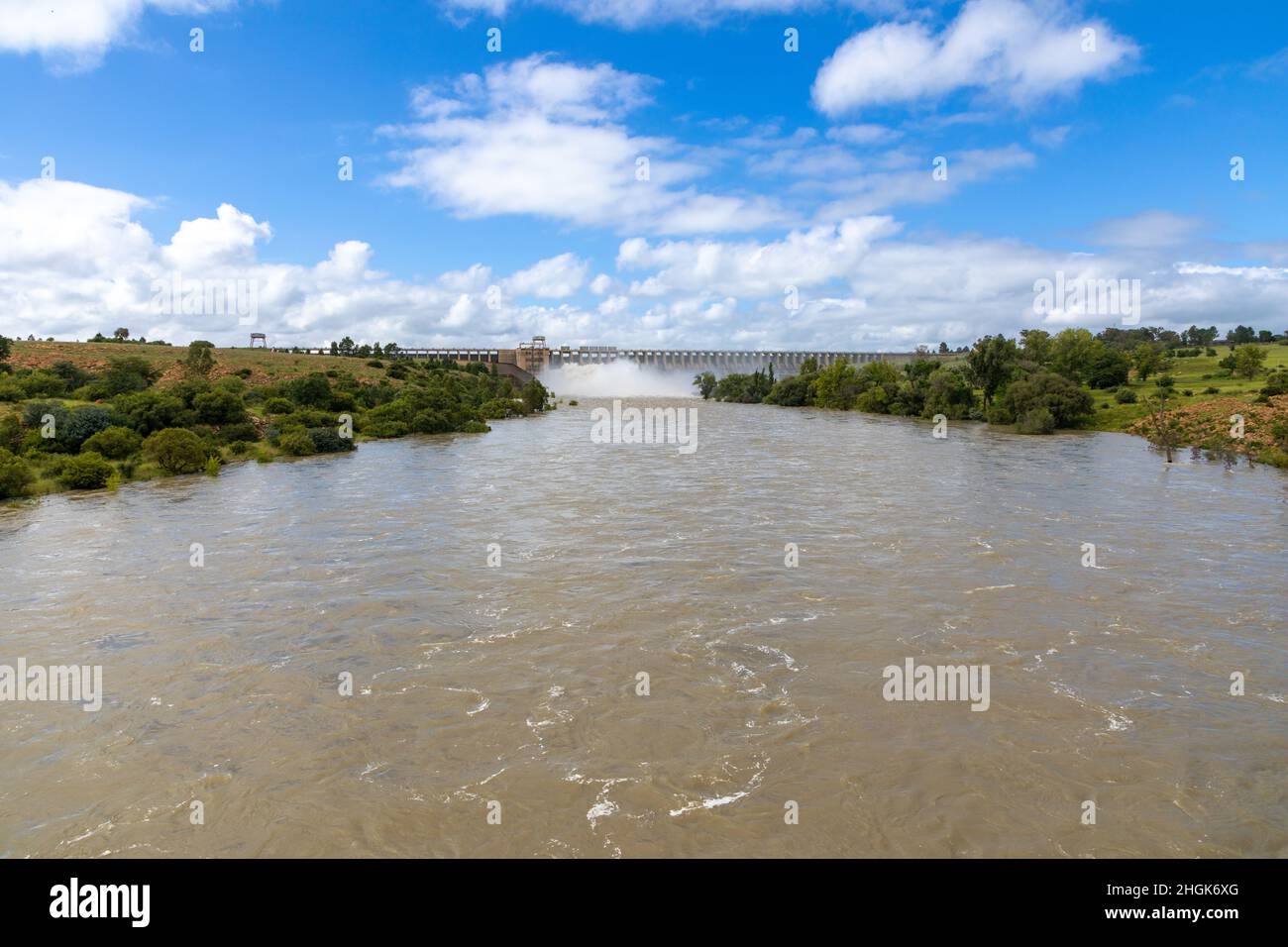 Fiume Vaal in alluvione con le chiuse aperte e muro diga del Vaaldam in Sud Africa dopo buone piogge sullo sfondo Foto Stock