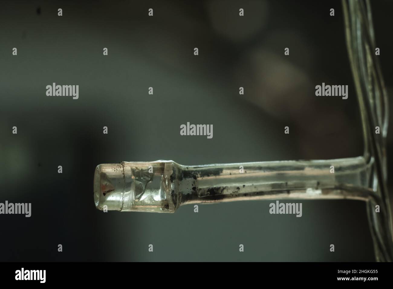 Macro primo piano vecchio piccolo bruciato bianco plastica pallida diodo ad emissione luminosa LED striscia di lampada di ghirlanda elettrica. Sfocatura dello sfondo. Oggetto esterno Foto Stock