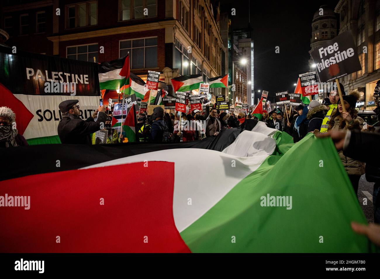 I dimostranti detengono bandiere e cartelli palestinesi che leggano "Palestina libera” durante la manifestazione. Centinaia di persone della comunità palestinese locale di Londra hanno protestato fuori dall'Ambasciata d'Israele per un raid di prima mattina da parte dei soldati israeliani a Sheikh Jarrah il 19th gennaio 2022. Hanno chiesto al governo israeliano di smettere di demolire le case nel territorio palestinese occupato e di fermare la pulizia etnica dei palestinesi. La folla in seguito si scagliò verso il centro di Londra con la scorta della polizia Met. (Foto di Hesther ng/SOPA Images/Sipa USA) Foto Stock