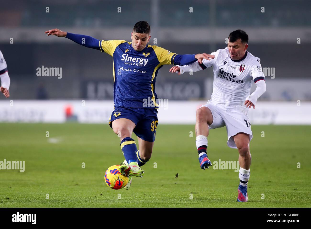 Verona, 21 gennaio 2022. Giovanni Simeone attaccante per Hellas Verona combatte per la palla con Gary Medel difensore per Bologna F.C. durante la Serie A partita di calcio tra Hellas Verona FC e Bologna FC. Credit: Stefano Nicoli/Speed Media/Alamy Live News Foto Stock