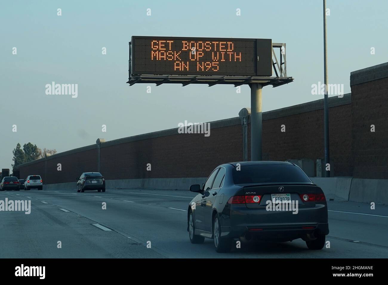 Una bacheca di Caltrans con il messaggio di servizio pubblico sul coronavirus COVID-19 sull'autostrada Interstate 5 con le parole "Get Boosted. Mascherare con N95,' per promuovere vaccinazioni di richiamo e maschera facciale indossando in mezzo all'ondata della variante omicron, mercoledì 19 gennaio 2022, a Norwalk, calib. Foto Stock