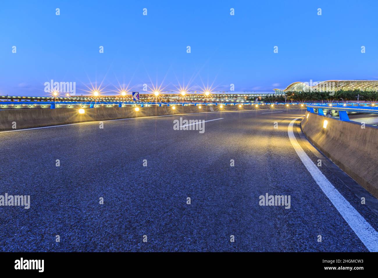 Strada asfaltata vuota con skyline moderno ed edifici all'aeroporto Foto Stock