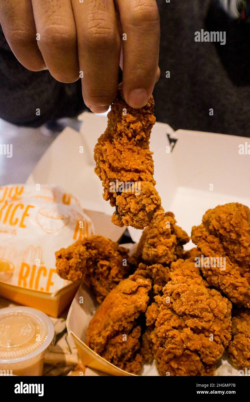 Prendere le ali di pollo fritte per mangiare Foto Stock