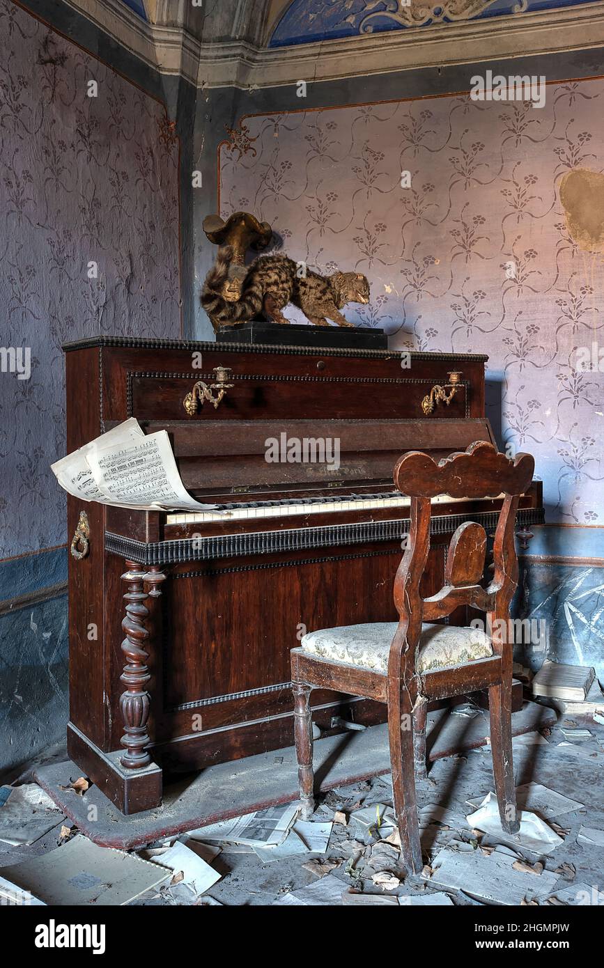 Novembre 2020, Italia. Pianoforte antico con una partitura musicale, in un soggiorno di una casa abbandonata nel Nord Italia. UrbEx in Italia Foto Stock