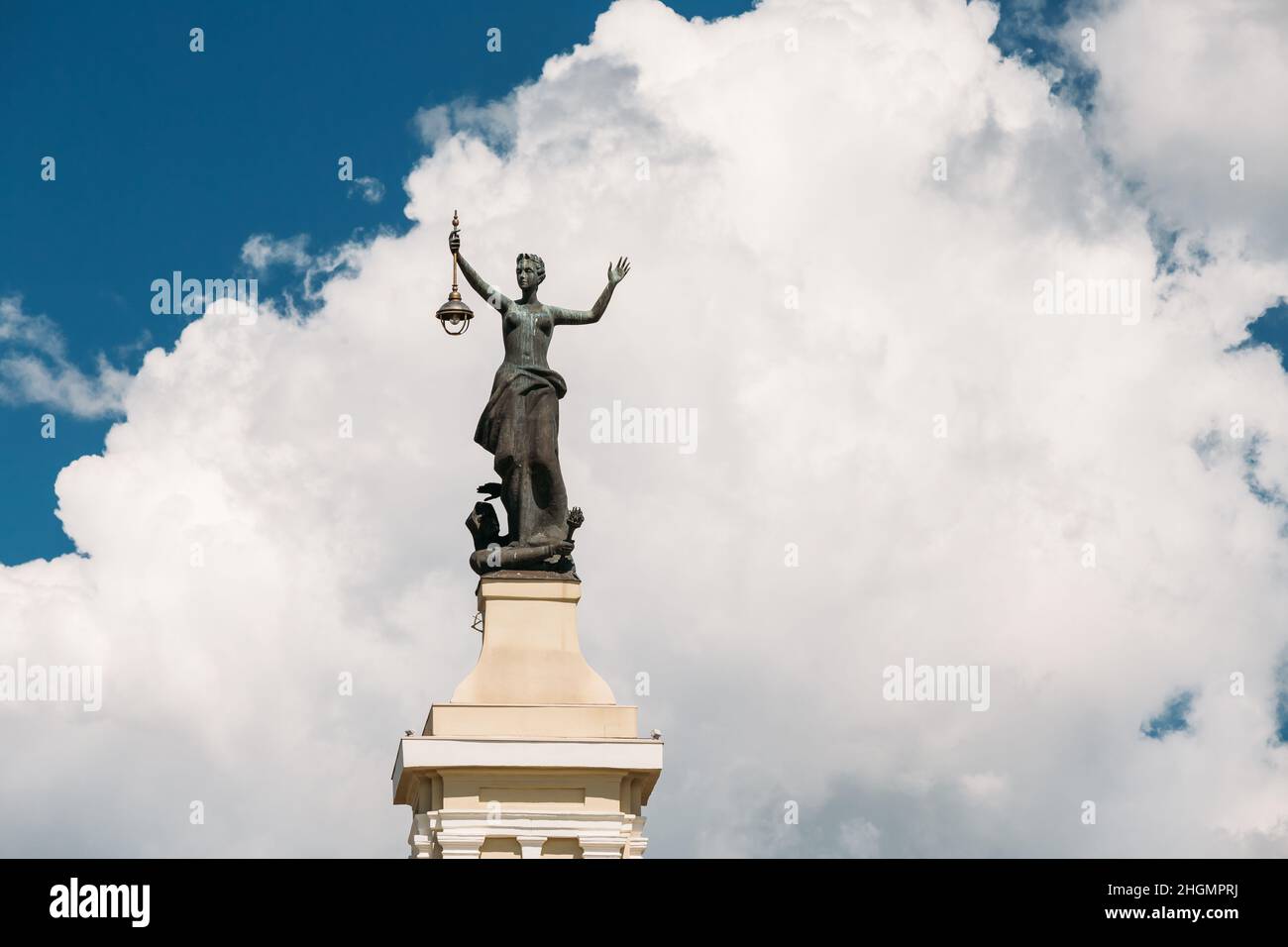 Vilnius, Lituania. Statua di una donna con una Lanterna nelle sue mani sul tetto del Museo dell'energia e della tecnologia contro Un cielo blu soleggiato Foto Stock