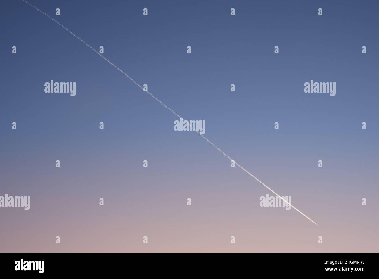 Velivolo bianco diagonale traccia su chiaro gradiente cielo sera dopo il tramonto. Traccia del piano. Foto Stock