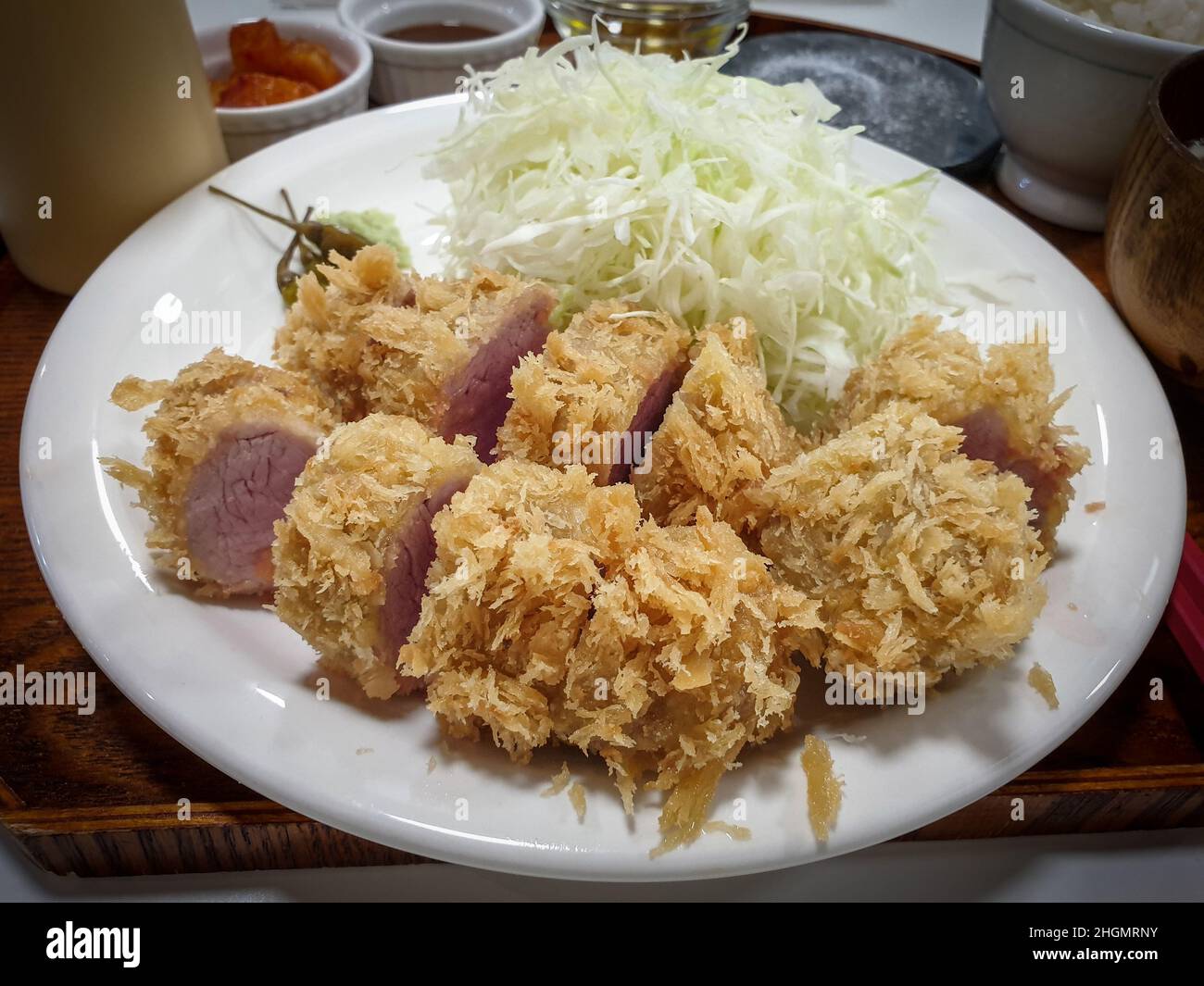 Tonkatsu, una cotoletta di maiale fritta e impanata giapponese. Servito con insalata di cavolo e wasabi. Foto Stock