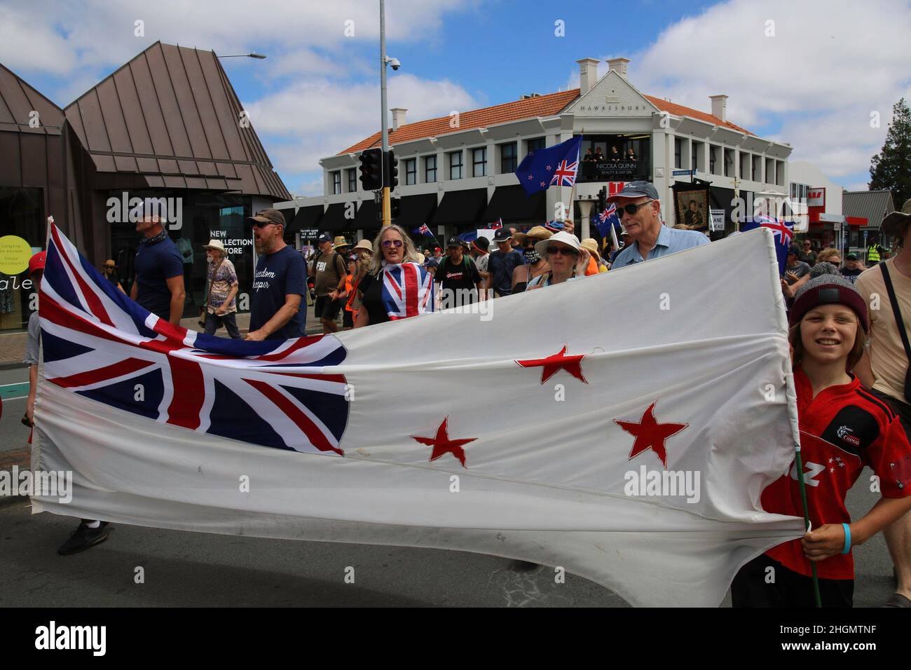 Christchurch, Nuova Zelanda. 22nd Jan 2022. I manifestanti detengono una bandiera neozelandese posta su uno sfondo bianco non tradizionale durante la protesta antivassica a Merivale. I manifestanti scendono per le strade del ricco sobborgo di Merivale per protestare contro la vaccinazione obbligatoria del Covid19. Credit: SOPA Images Limited/Alamy Live News Foto Stock