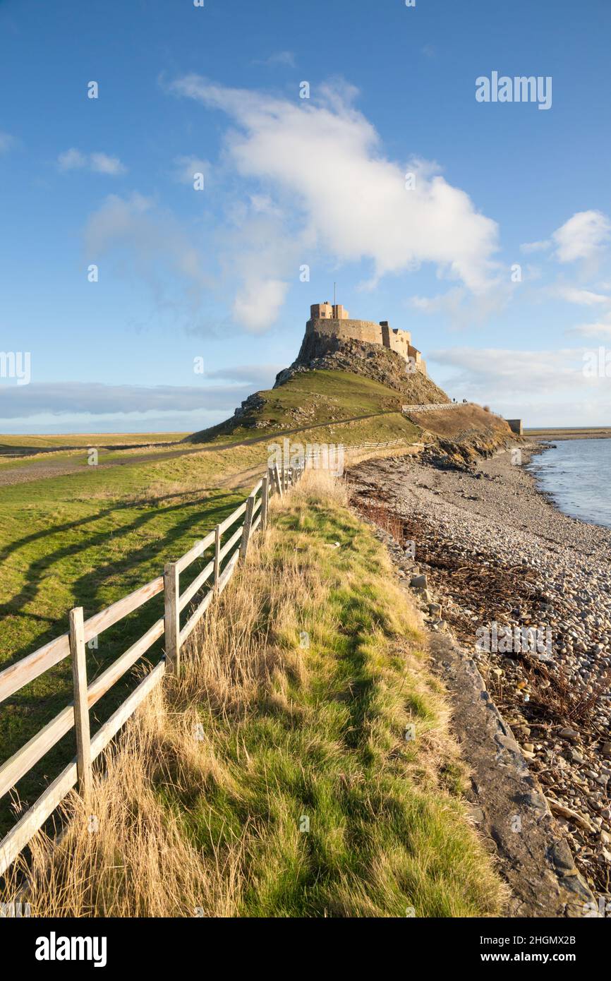 Castello di Lindisfarne a Holy Island, Northumberland, in un giorno d'inverno luminoso e soleggiato con linea di recinzione e forti ombre dal sole d'inverno. Foto Stock
