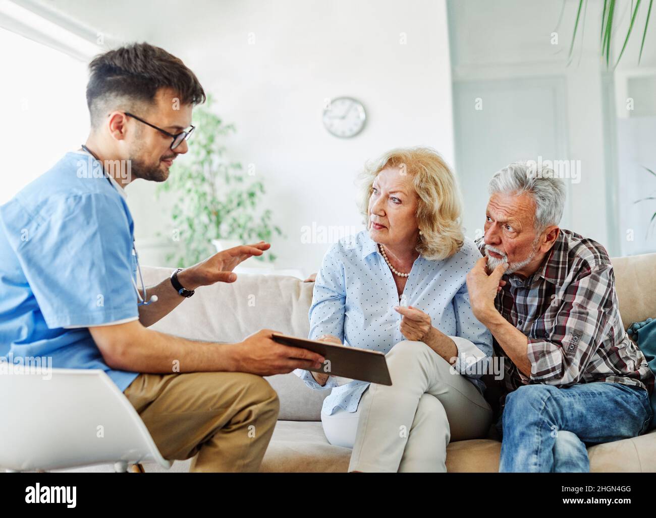 infermiera medico anziano cura di coppia caregiver aiuto pensione assistenza casa infermieristica anziano uomo donna tablet tecnologia Foto Stock