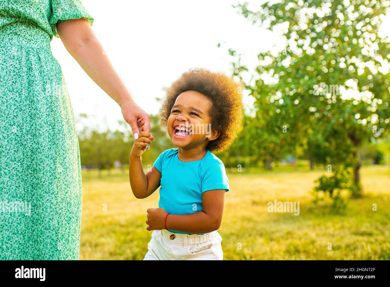 bambina con capelli ricci freschi afro divertirsi insieme con la mamma outdor Foto Stock