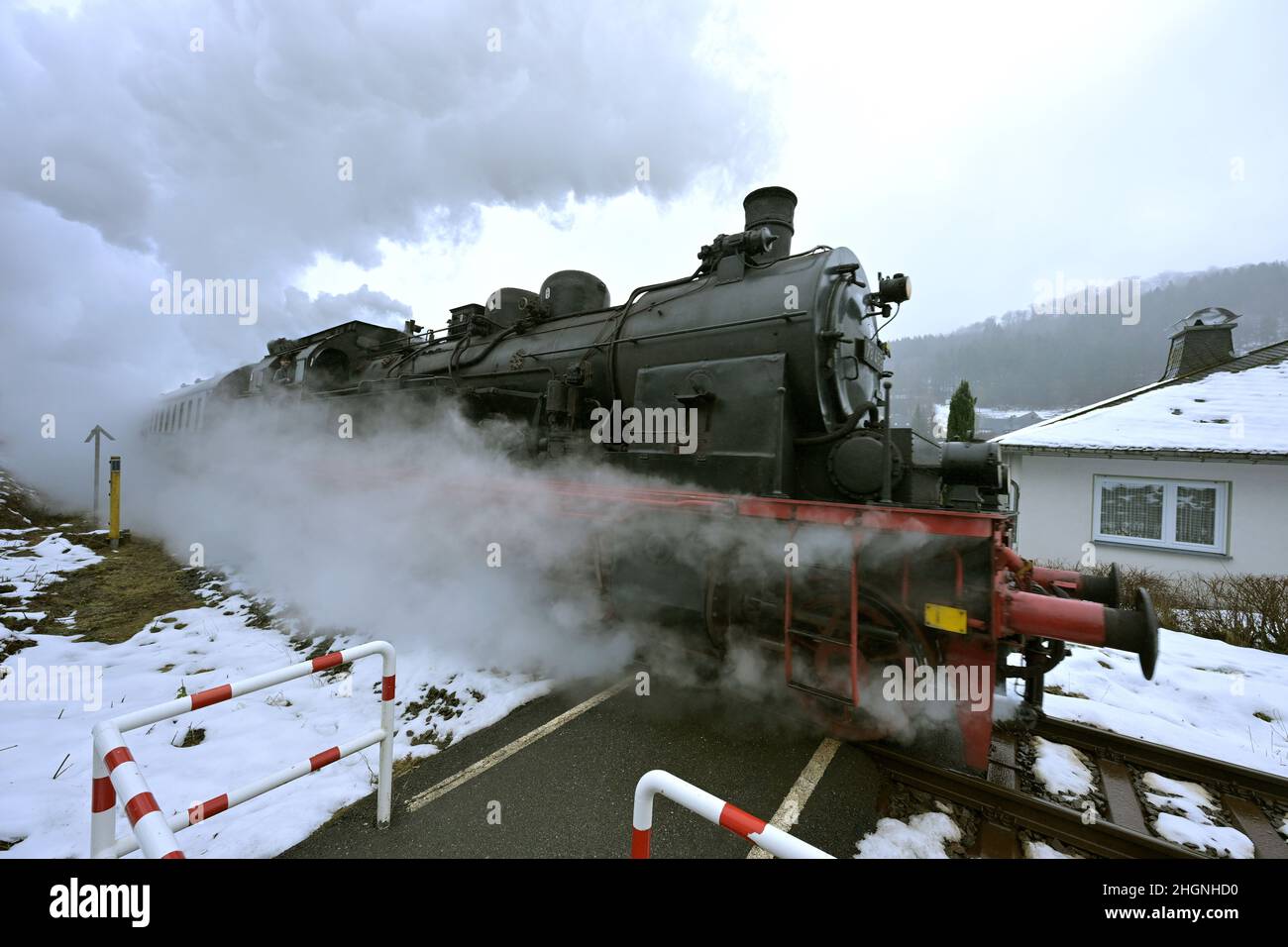 Winterberg, Germania. 22nd Jan 2022. Un treno storico passa attraverso il villaggio innevato di Sauerland. La storica locomotiva a vapore è un T18 prussiano del 1920s. Con il titolo "Toboggan Steam to the Sauerland", la Bielefeld Railway Friends Association guida una storica locomotiva a vapore da Bielefeld a Winterberg. A bordo ci sono diverse centinaia di fan della ferrovia, che slittano sulle piste con le loro slitte a destinazione. Il treno si ferma anche a Paderborn, Lippstadt, Soest, Unna e Arnsberg, tra gli altri luoghi. Credit: David Inderlied/dpa/Alamy Live News Foto Stock