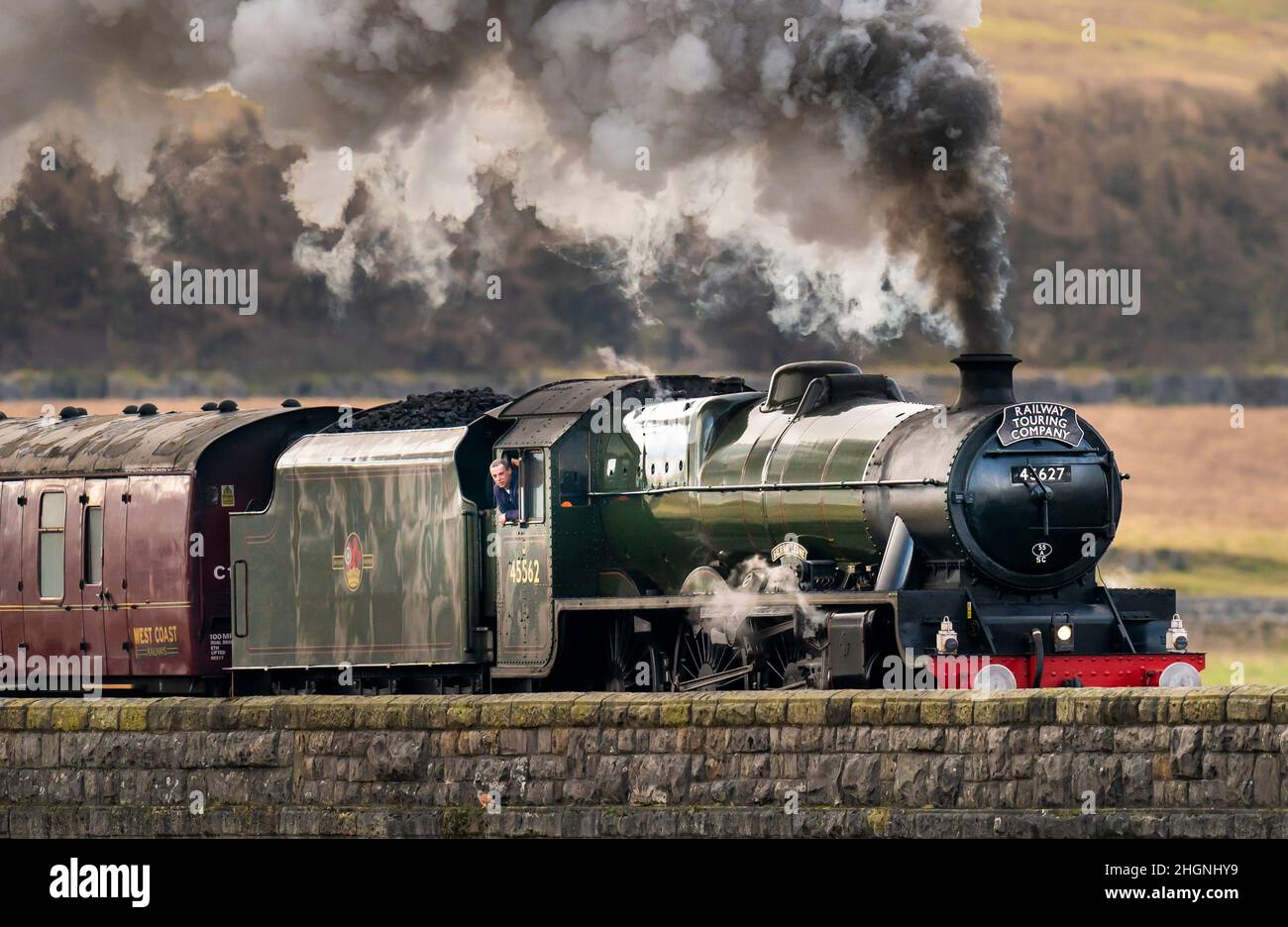Una persona si affaccia dalla vedova del Winter Cumbrian Mountain Express trainato da 45699 Galatea, la prima linea principale treno trainato a vapore della società del 2022, attraversa Ribblehead Viaduct nello Yorkshire Dales National Park. Data foto: Sabato 22 gennaio 2022. Foto Stock