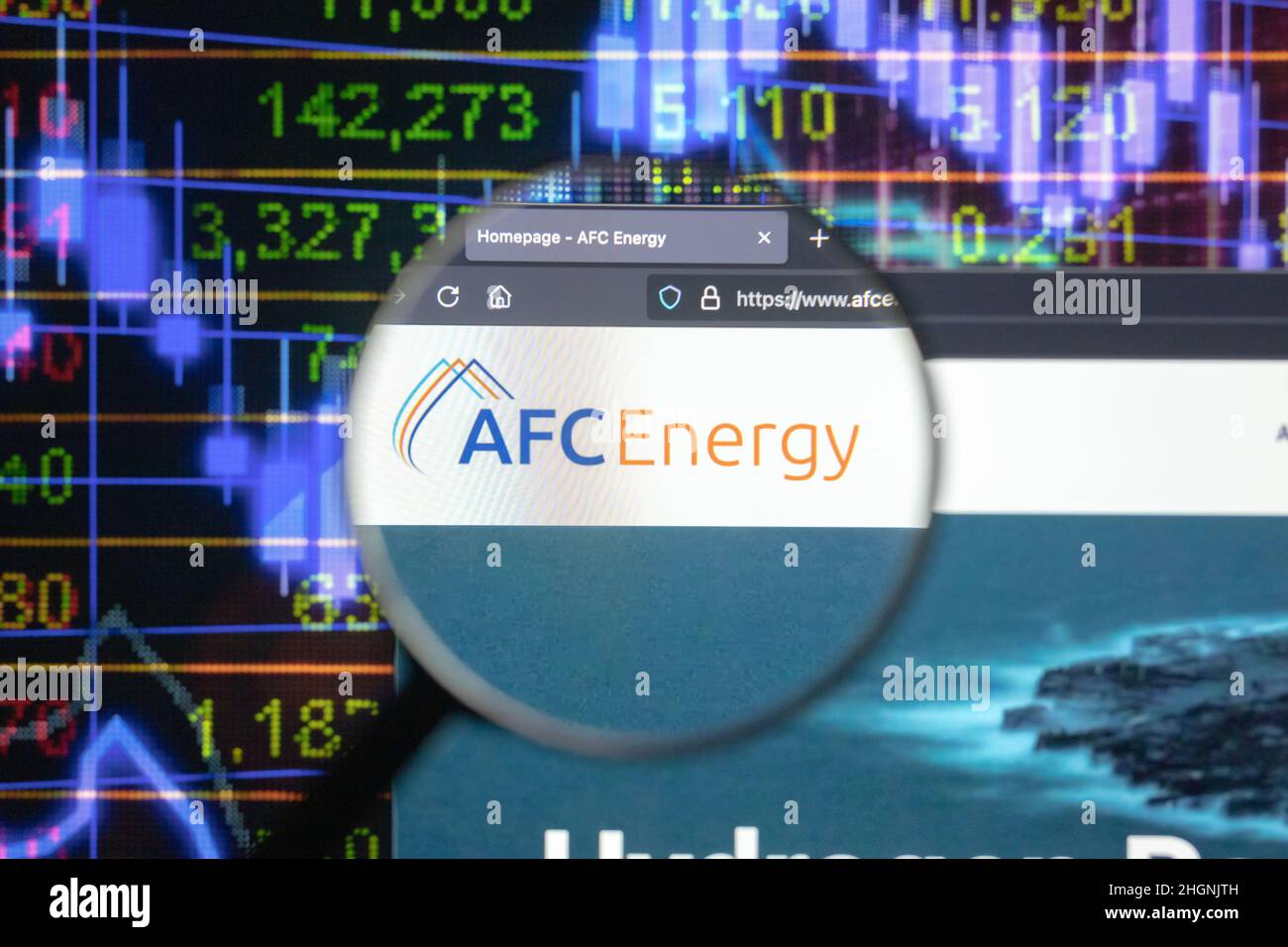 AFC Energy Company logo su un sito web con blurry mercato azionario sviluppi in background, visto su uno schermo di computer attraverso una lente d'ingrandimento. Foto Stock