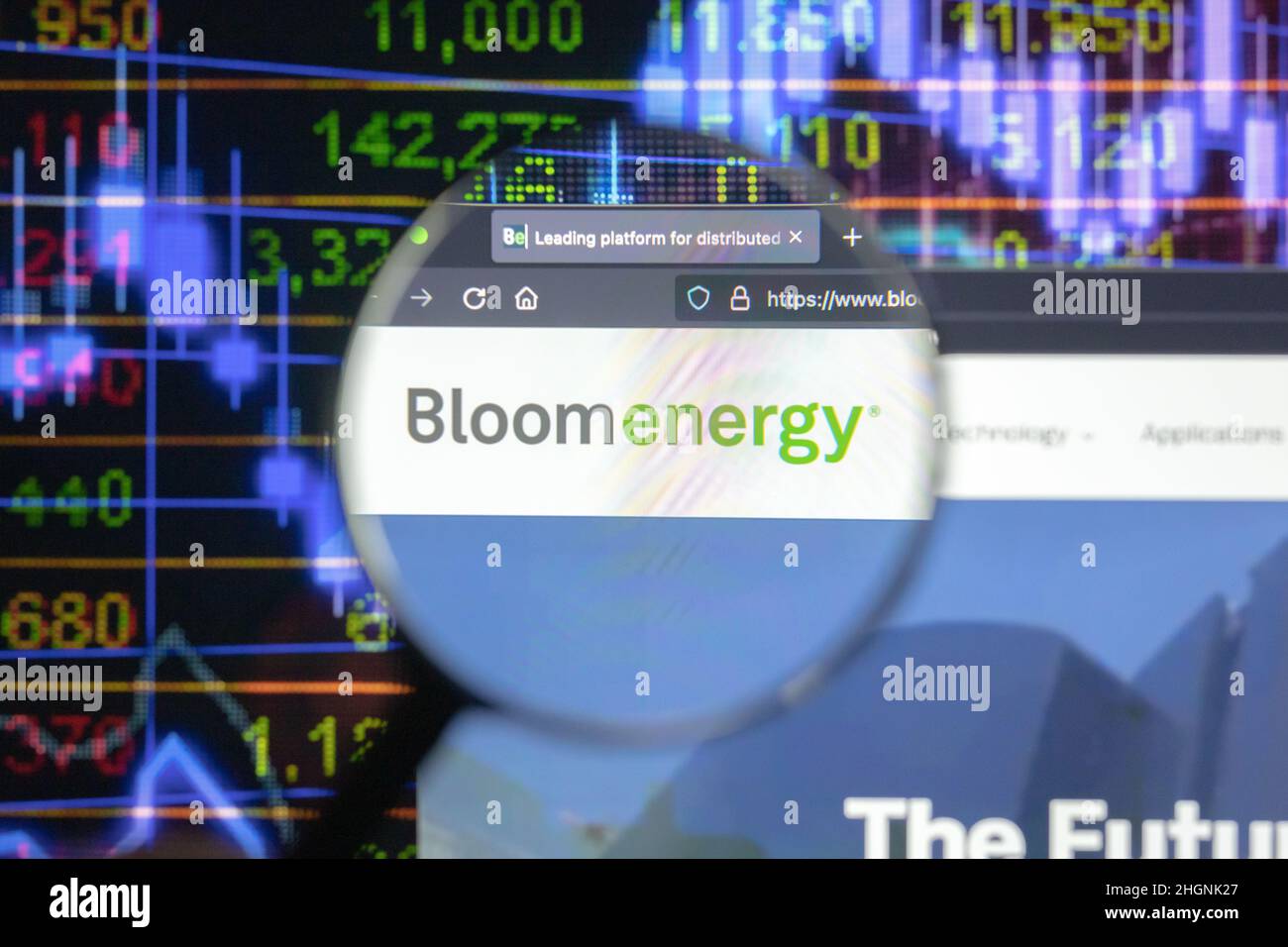Bloom Energy Company logo su un sito web con blurry sviluppi del mercato azionario in background, visto su uno schermo del computer attraverso una lente d'ingrandimento. Foto Stock